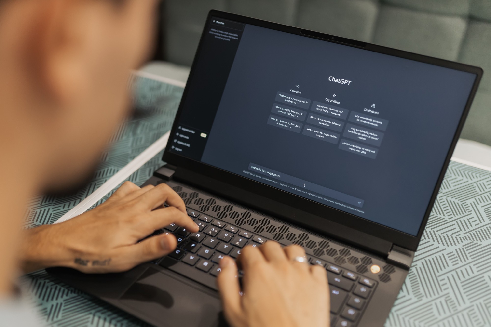 Pessoa a escrever uma pergunta ao ChatGPT num computador portátil